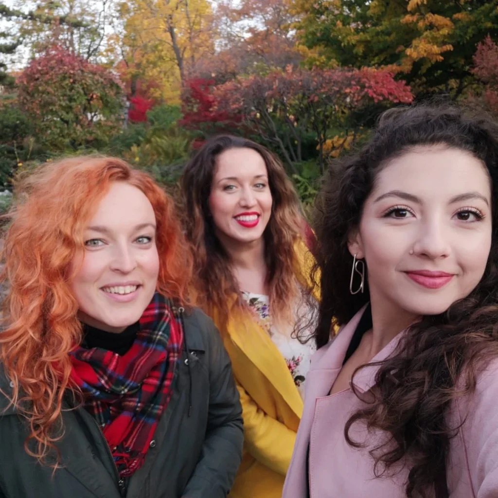 Traveliso team portrait – three women smiling outdoors in autumn scenery