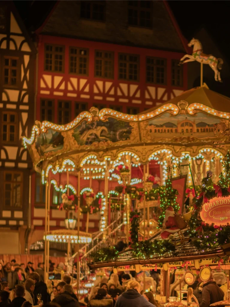 Nighttime Christmas market with carousel and festive lights.