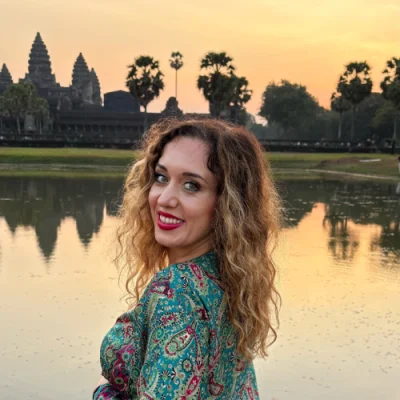 Vesna Karalić – Founder of Traveliso Vesna Karalić smiling at sunset in front of Angkor Wat temple